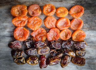 Assortment of dried apricots and dates on aged wood.