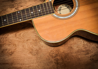 Vintage acoustic guitar on rustic wood background.