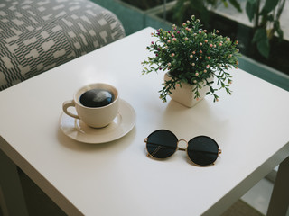 coffee and sunglasses on table in coffee with film vintage style