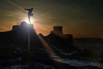 Człowiek na linie na zamku w Olsztynie o zachodzie słońca.