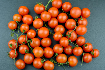 Tomaten - Cocktailtomaten mit Rispe auf einer Schieferplatte