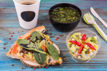 Fast set. Mushrooms soup, piece of vegetable pizza and fruit salad