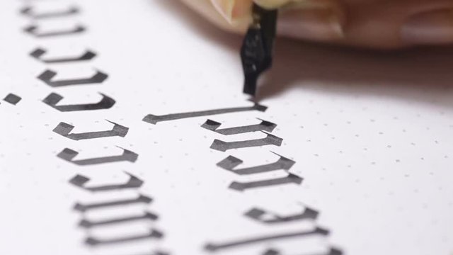 Woman writes pen with calligraphic letters