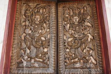 The carved wood window shaped of human and in a frame.