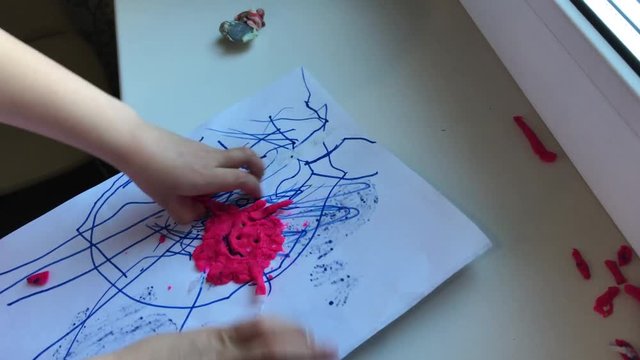 Children's creativity. The child plays with plasticine. Destroys his work. A figurine with an emoticon is fashioned on paper. Video shot on the iPhone 7 Plus_1