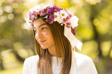 Young woman with flowers in her hair on sunny spring day