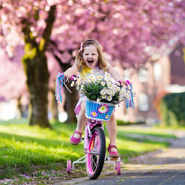 Little girl riding a bike. Child on bicycle.