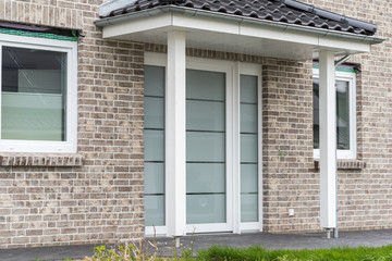Große moderne Haustür mit weißen Rahmen und Vordach