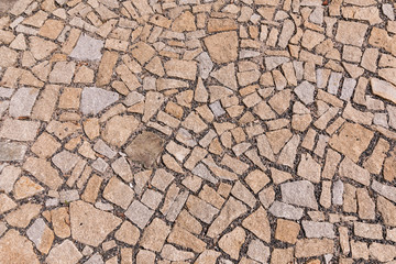 Paving blocks made of asymmetrical stone. The stone pavement as the background texture.