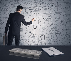 Businessman writing strategy plan on wall