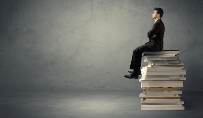 Stylish male seated on books