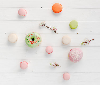 macarons and doughnuts, blossoming flowers, topview