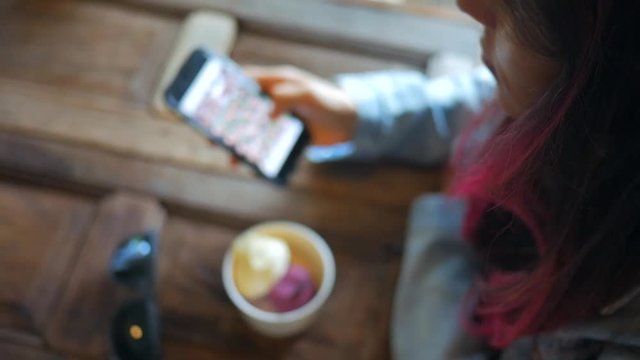 Young Caucasian Girl with Colored Pink Hair Using Mobile Phone and Eating Ice-cream in Cafe. HD Slowmotion. Koh Phangan, Thailand. 1920x1080