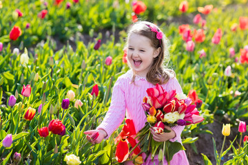 Little girl in tulip flower garden