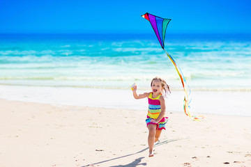 Child flying kite on tropical beach