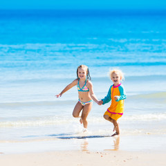 Naklejka premium Kids run and play on tropical beach