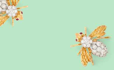 Bumble bee diamond brooch on green background with negative space