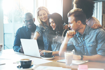 Woman showing coworkers something on laptop