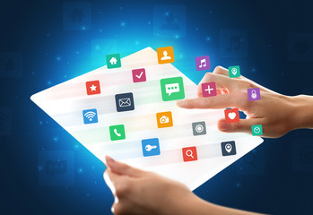 Hands touching a glass-like tablet with colorful icons