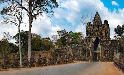 South gate to Angkor Thom and the faces of stone giants guarding the entrance, Siem Reap, Cambodia. The road to the Angkor Thom