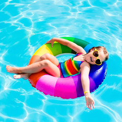 Child with toy ring in swimming pool