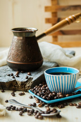 Coffee cup and metal turk on burlap background