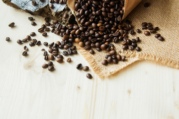 Close up roasted coffee beans in paper bags on wooden background