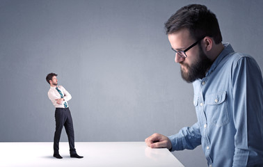 Young businessman fighting with miniature businessman