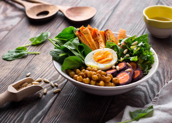 Lunch bowl with sweet potatoes, chickpeas, spinach, carrots and boiled egg