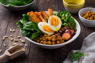 Lunch bowl with sweet potatoes, chickpeas, spinach, carrots and boiled egg