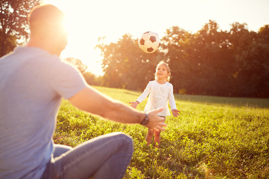 Girl and her father plays with ball