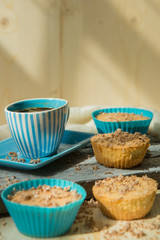 Chocolate muffin with soft cream and fresh blueberry powdered with sugar, cup of coffee, rustic background