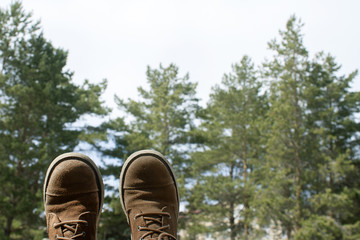 Old traveler's boots against the backdrop of the forest