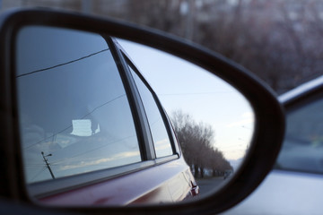 View from the car window in the rearview mirror