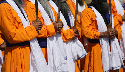 men with the swords and cerimonial clothes druing a sikh parade