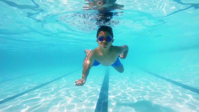 Boy swimming underwater in pool