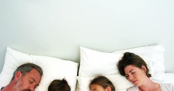 Family sleeping in bedroom
