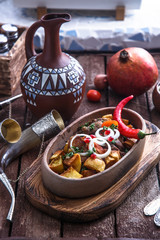 Ojaxuri, roasted pork and potatoes with onion and pomegranate seeds. Top view.