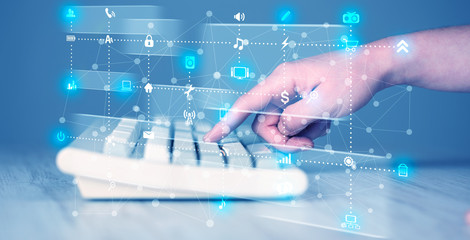 Hand pressing keyboard with high tech media icons
