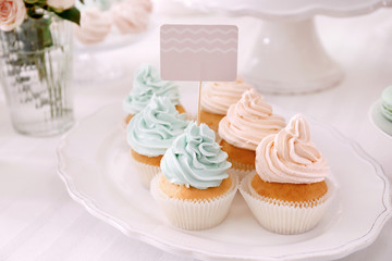 Obraz na płótnie Canvas Plate with tasty cupcakes on table