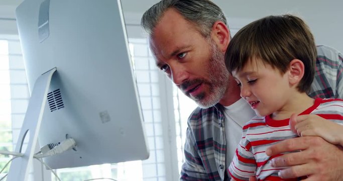 Father and son using desktop pc