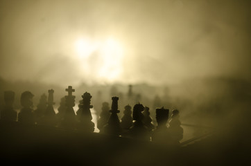 Fototapeta premium chess board game concept of business ideas and competition and strategy ideas concep. Chess figures on a dark background with smoke and fog.