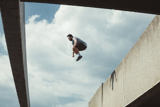 young man doing parkour jump  in the city