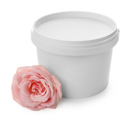 Plastic bucket with sugaring paste and flower on white background