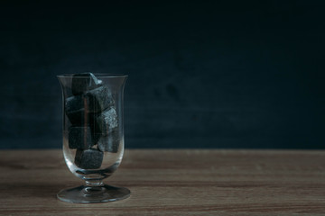 Stones for cooling whiskey and glases tulup on dark wooden background