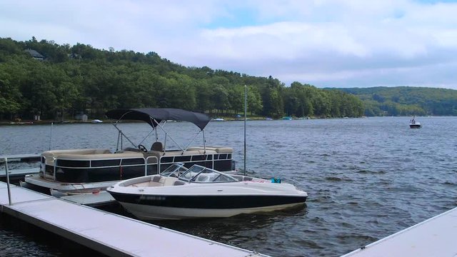 Anchored Boats Near Dock Bobbing on Lake During Cloudy Summer Day