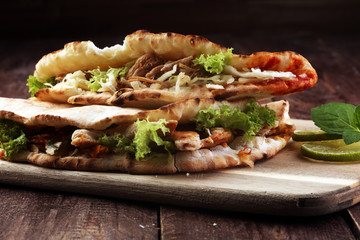 Delicious kebab sandwiches on wooden table