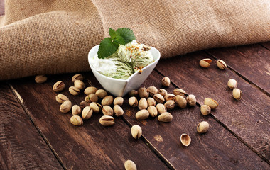 Fototapeta na wymiar Pistachio ice cream with chopped nuts and honey on a rustic background