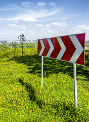 Red road sign shows direction