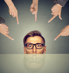 surprised businessman peeking from under the table